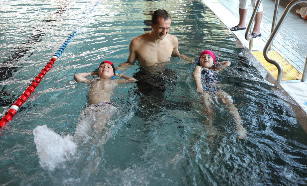 Beim Schwimmkurs für Nichtschwimmer im Sportbad An der Elster in Leipzig hilft Trainer Maximilian Göhring Oskar und Greta beim Schwimmen. Foto: André Kempner