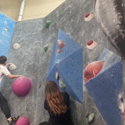 Zwei Jugendliche beim Bouldern an der Kletterwand.