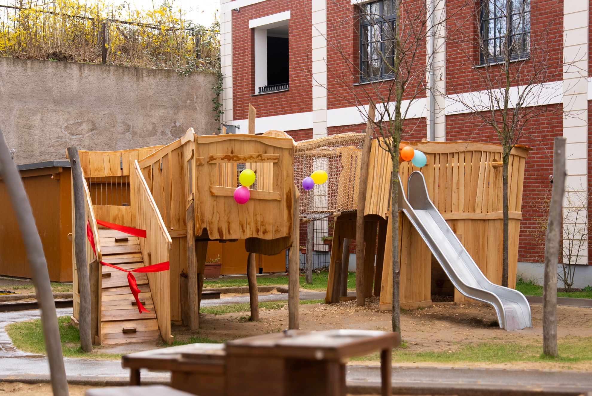 Ein Klettergerüst aus Holz mit Rutsche und Hängebrücke